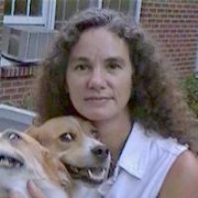 Woman with long dark curly hair pictured with two dogs